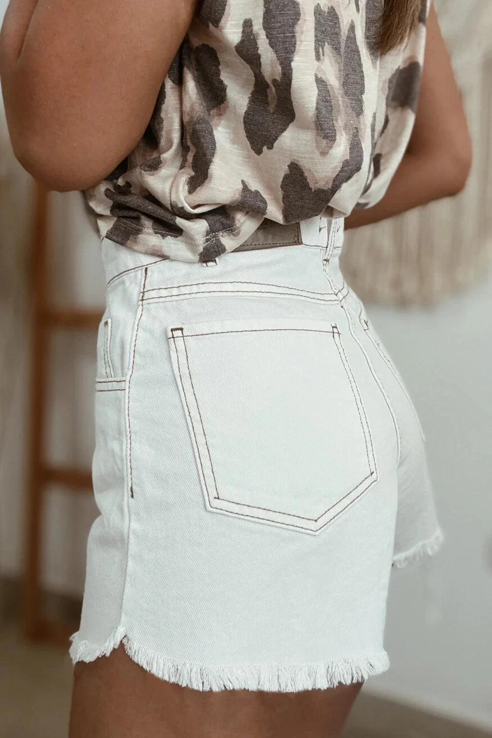 White Denim shorts with brown stitching that are stretchy and have a 3.1 inch inseam 