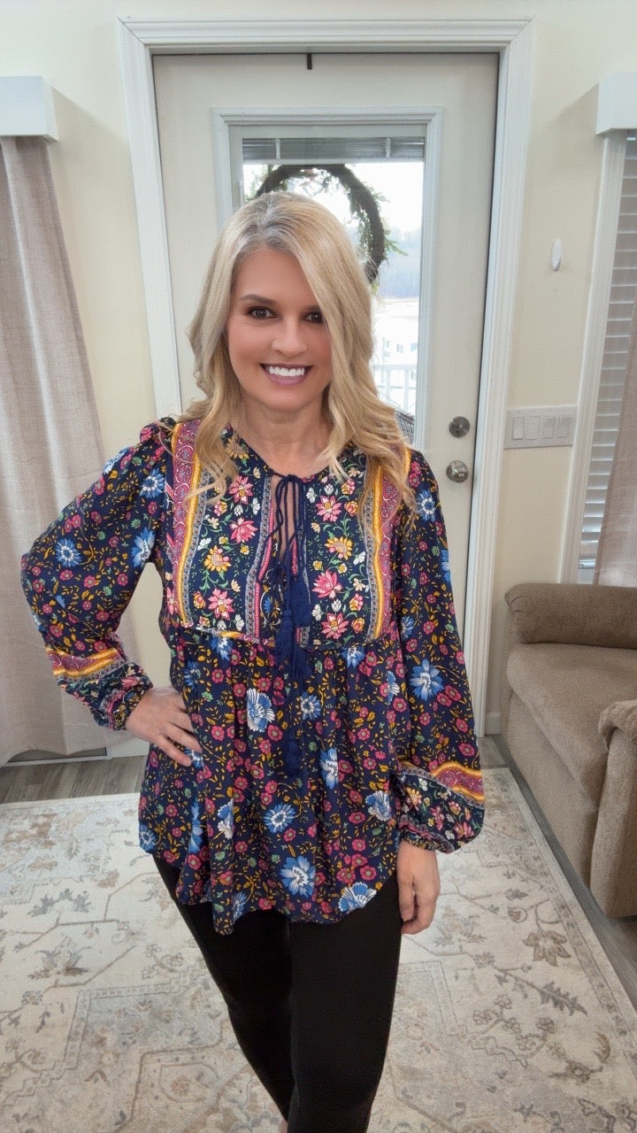 Woman wearing a colorful floral blouse in a living room setting