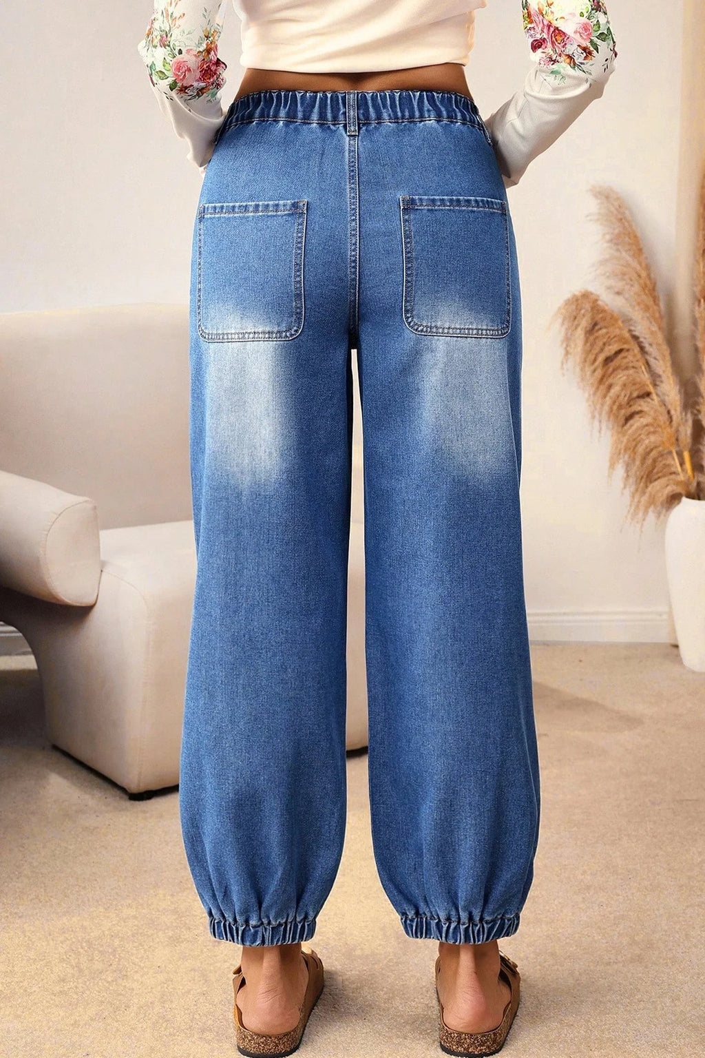 Blue denim pants worn by a person indoors with a neutral background